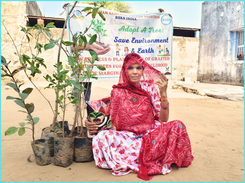 A woman in a red traditional outfit sitting on the ground, holding a small plant in a pot, with several young plants in bags beside her. A banner in the background promotes tree adoption and environmental awareness.