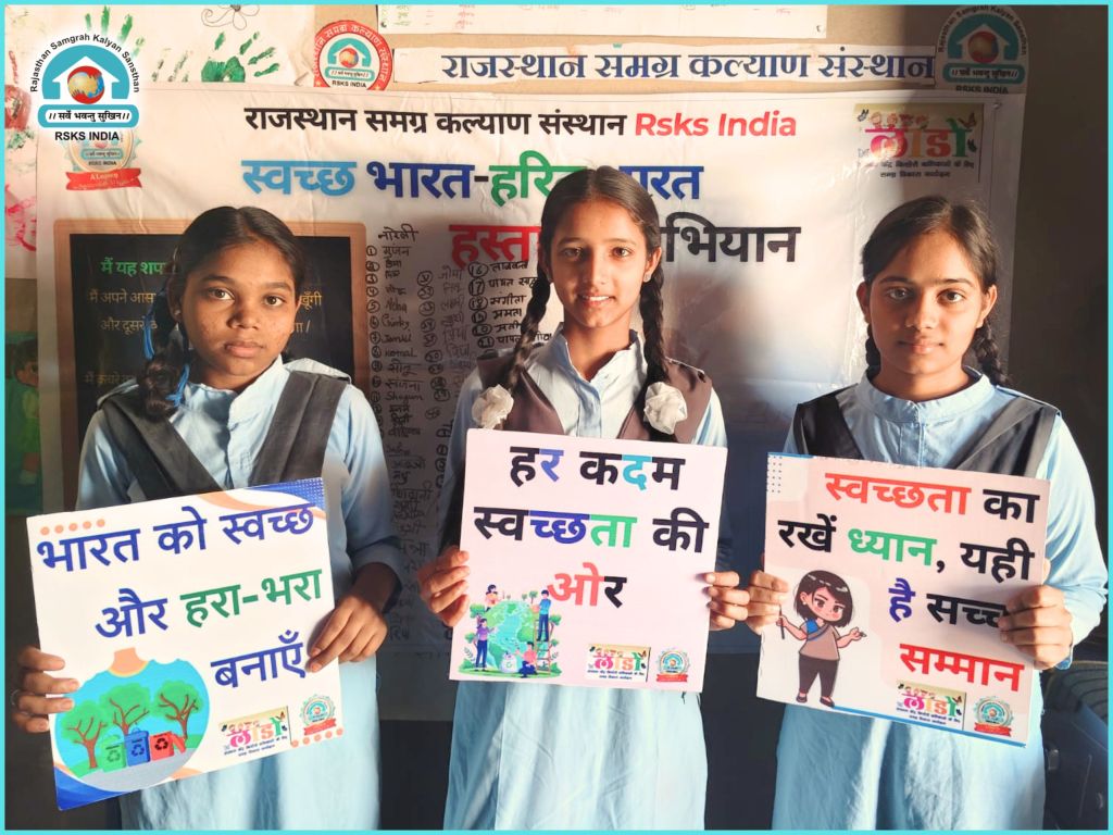 Three students holding placards promoting cleanliness and environmental awareness in a classroom setting.